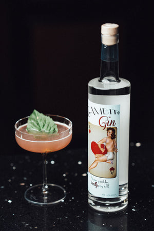 Bottle of gin with a cocktail on a dark surface