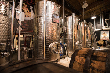 Aging barrels and fermentation tanks on Lucky Bastard Distillers' production floor