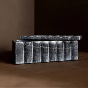 Decorative stone box with a textured surface on a brown background